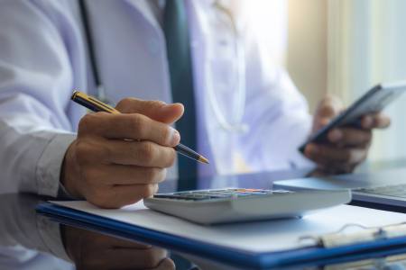 Person using a calculator to determine the costs of CoolSculpting