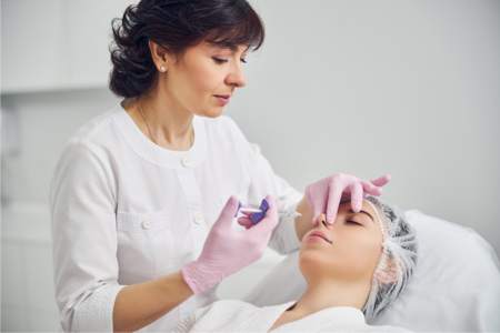 Plastic surgeon performing liquid rhinoplasty service on a patient