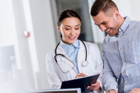 Plastic surgeon and client laughing while discussing the safety of CoolSculpting for arms