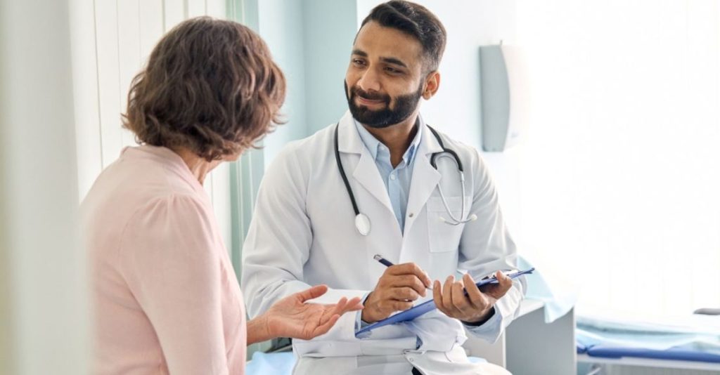 A plastic surgeon discussing Morpehus8 side effects with an interested client