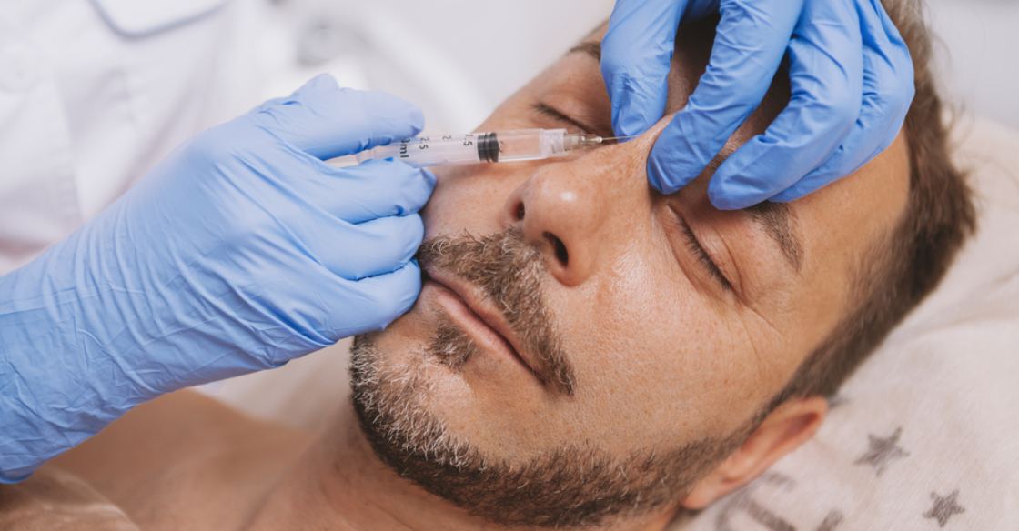 Plastic surgeon injecting filler to fix a dent in the nose